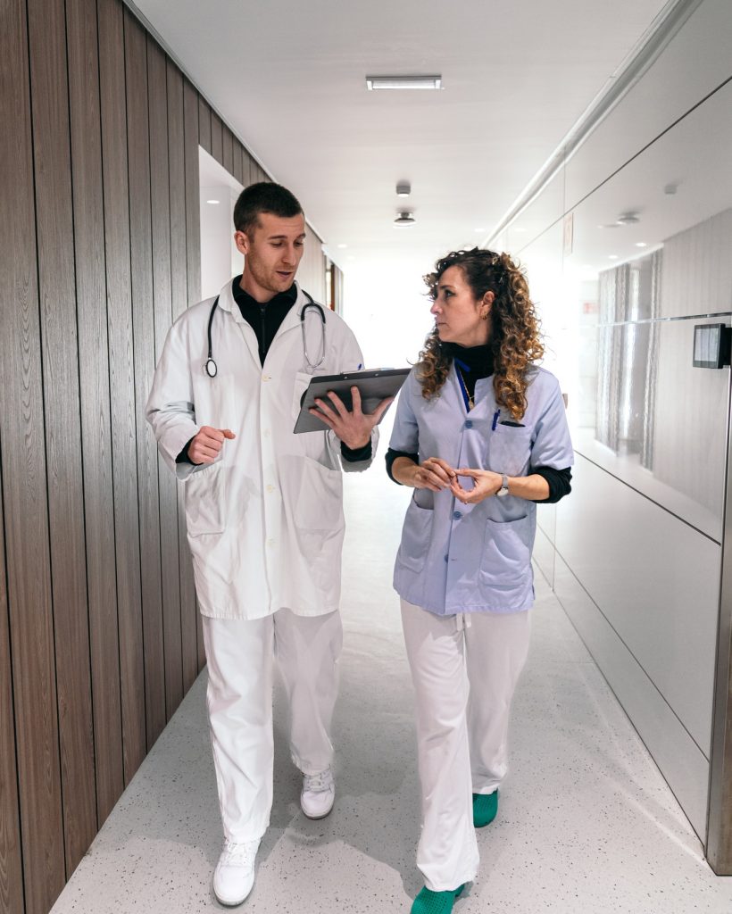 Healthcare Staff Conversing on Patient Care in Corridor
